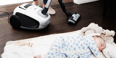 L’aspirateur VX8 fonctionne en silence alors qu’un bébé dort sur un tapis