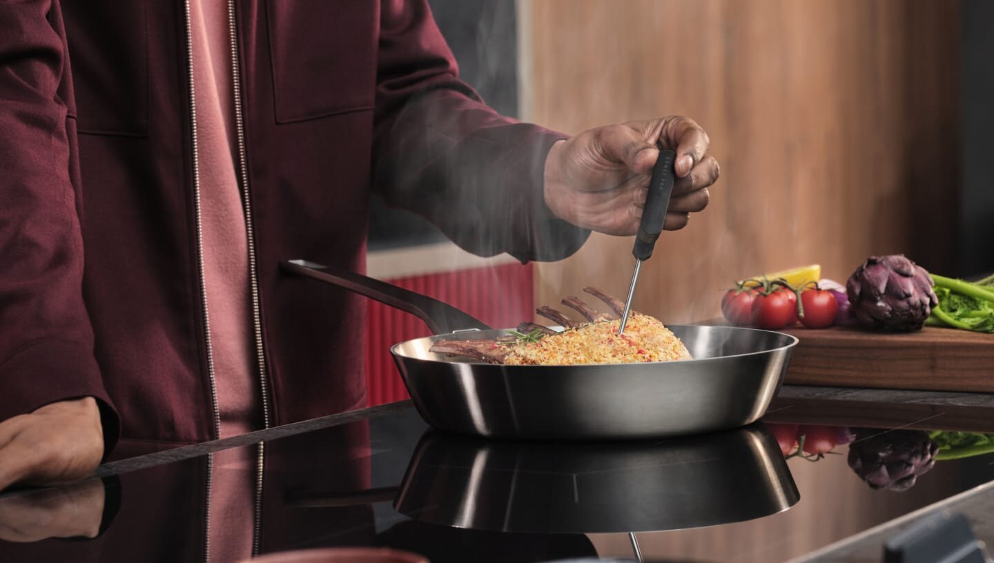 Une personne prépare des aliments sur une taque de cuisson à induction.