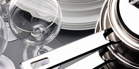 Un verre à vin éclatant placé à côté d'une série de casseroles