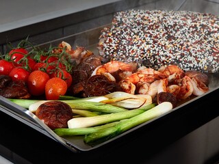 Poisson et légumes cuisant ensemble sur la plaque Teppanyaki