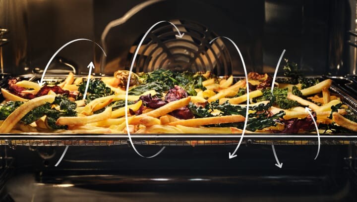 Des frites et des légumes cuisent au four.