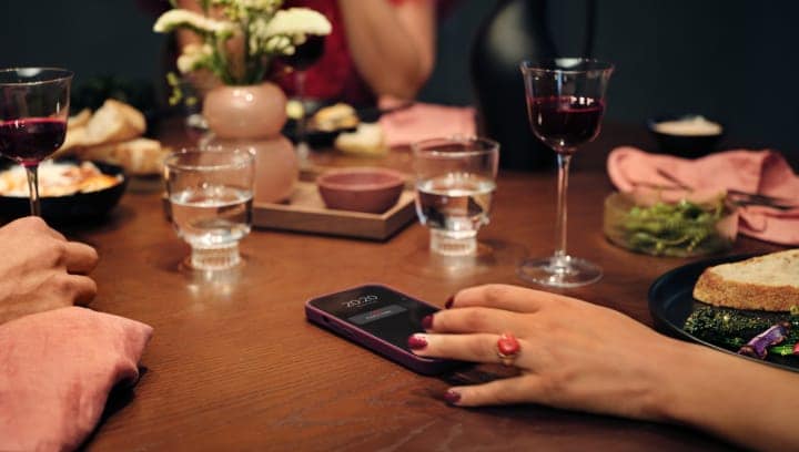 Des personnes assises autour d'une table avec de la nourriture et des boissons. 