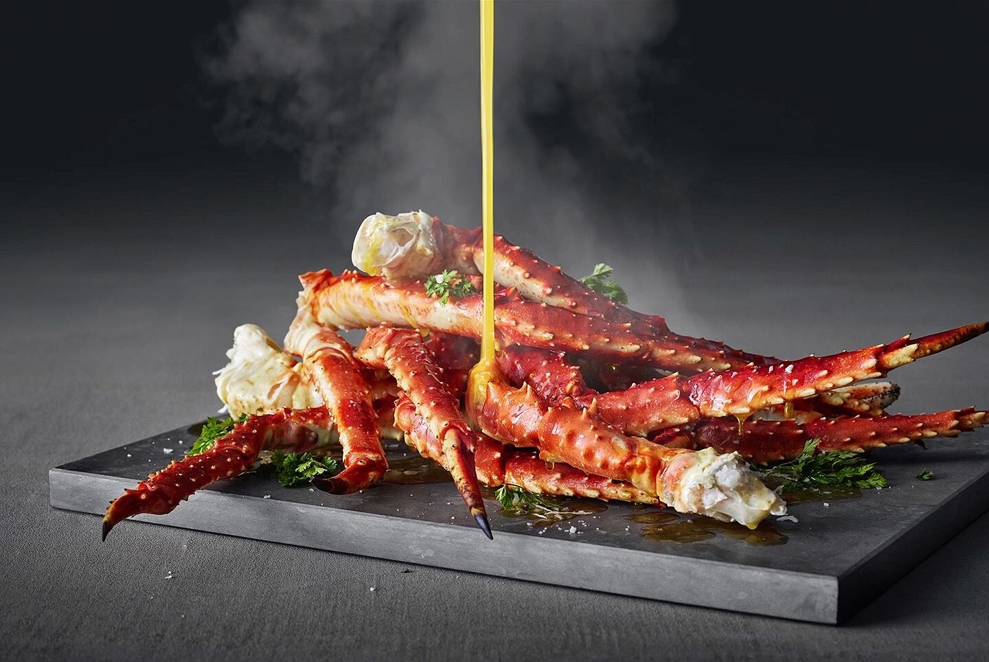 Sauce versée sur des pinces de crabe fumantes. Sauce versée sur des pinces de crabe fumantes.