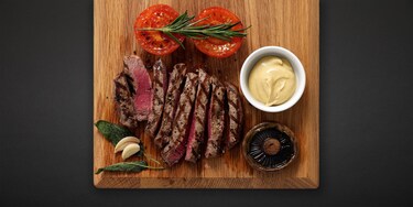 Un plat composé de viande grillée sur une planche en bois