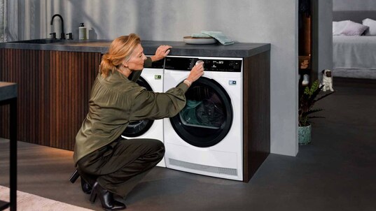Femme qui programme un sèche-linge