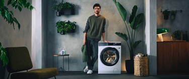 Un homme debout près d’un lave-linge