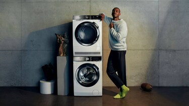 Un homme debout près d’un lave-linge