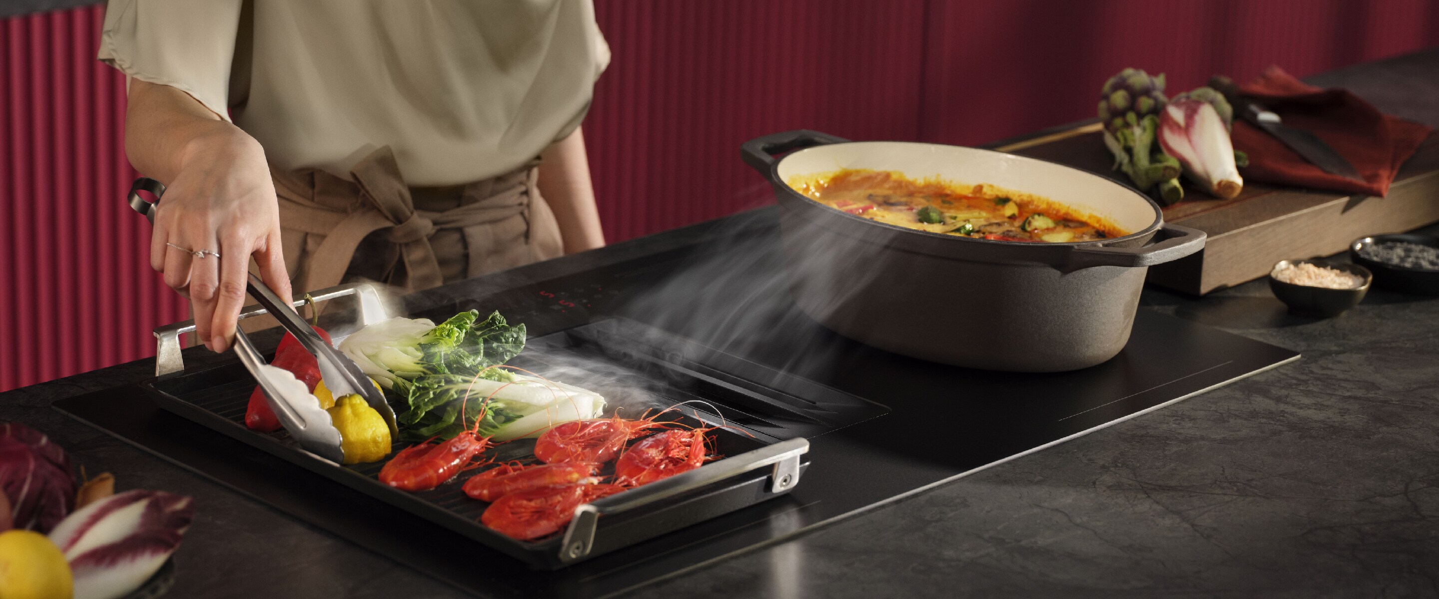 Femme debout dans la cuisine avec une taque à induction SaphirMatt®