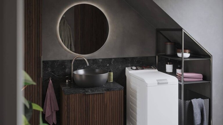 Lave-linge AEG à chargement par le haut dans une salle de bains.