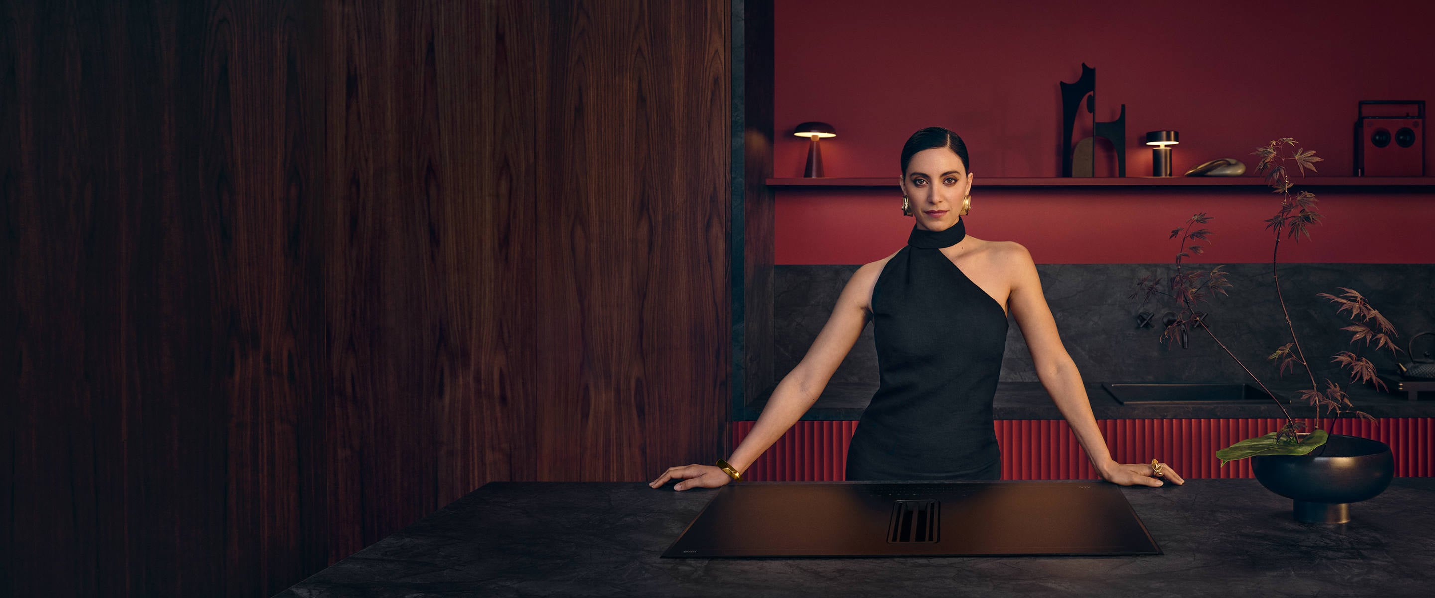 Femme debout dans la cuisine avec une taque à induction SaphirMatt®