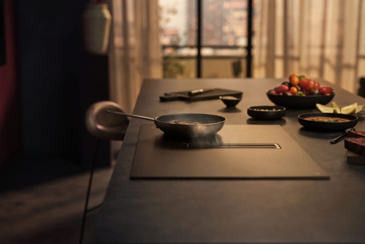 Poêle posée sur une table de cuisson dans une cuisine.