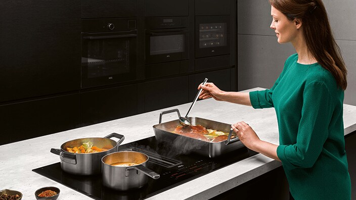 Femme cuisine sur un îlot de cuisine