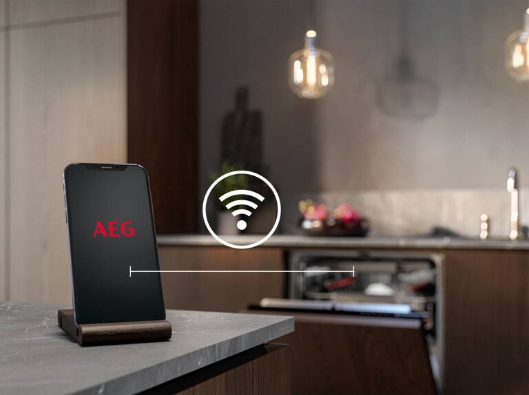 Lave-vaisselle ouvert avec téléphone au premier plan